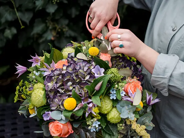 Ceremony flower arrangement with pampas grass, white delphiniums, white hydrangea, beige roses and hanging green amaranthus